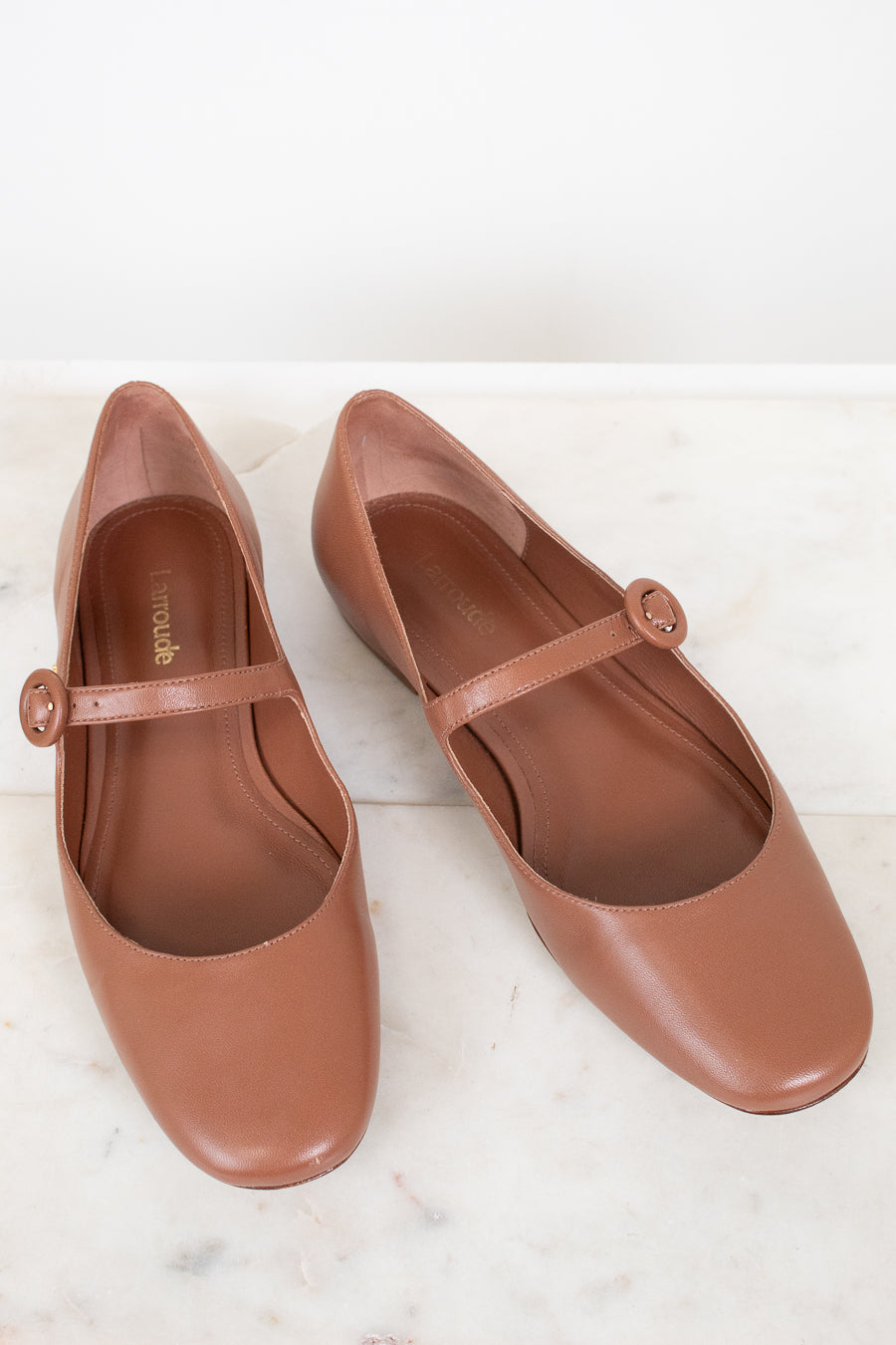 Pair of brown shoes with a strap on a white background