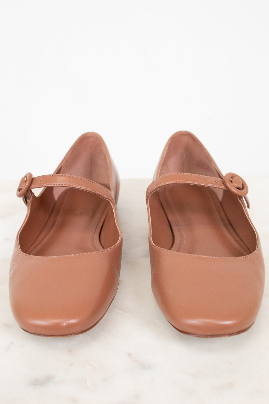 Pair of brown shoes with a strap on a white background