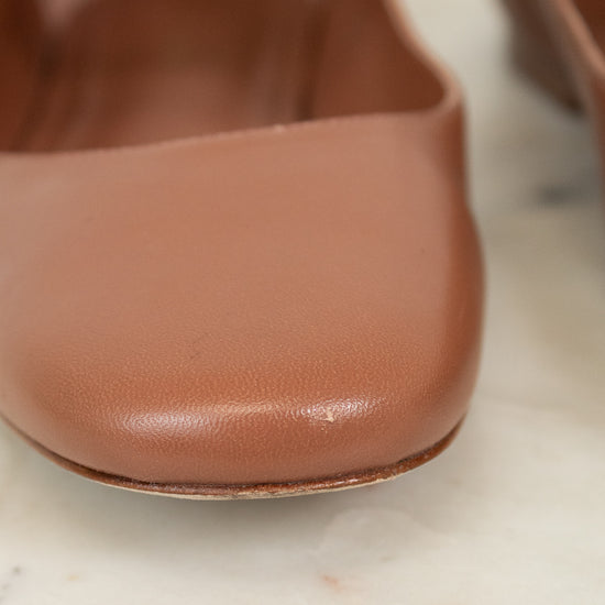 Close-up of a brown leather shoe on a light marble surface