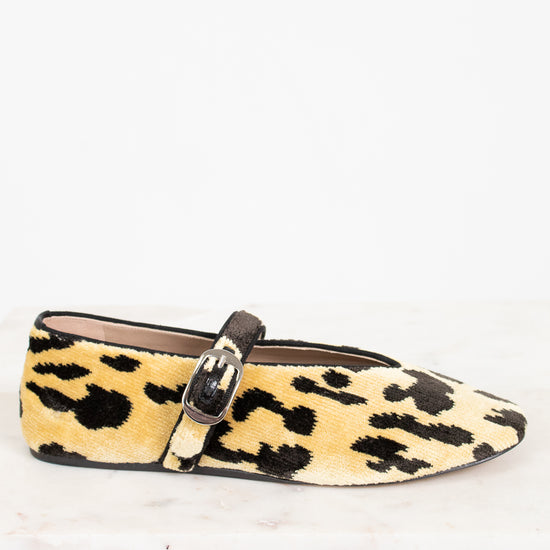 Leopard print flat shoe with a strap on a white background