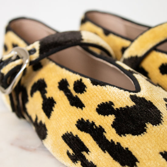 Yellow leopard print shoes with a strap on a light background