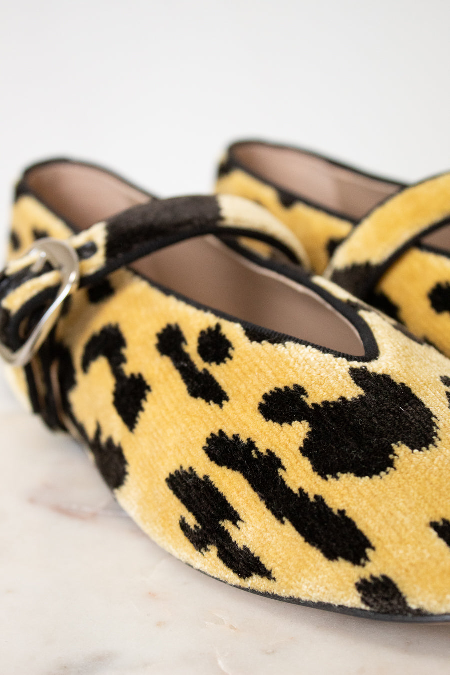 Yellow leopard print shoes with a strap on a light background