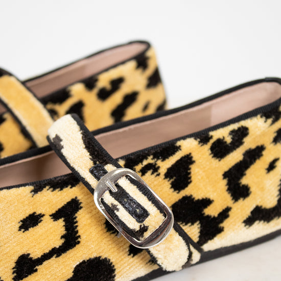 Leopard print loafers with a buckle on a light background