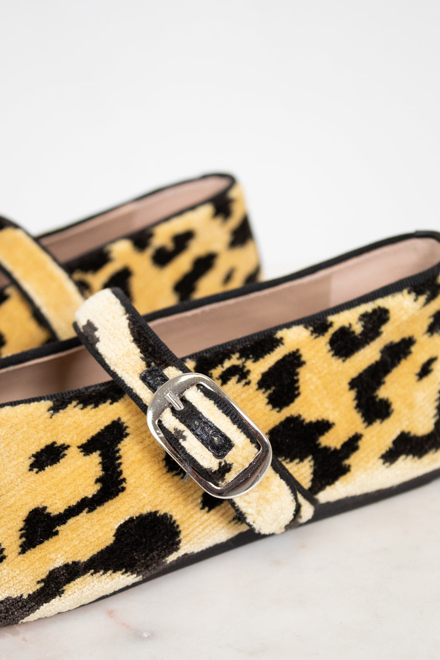 Leopard print loafers with a buckle on a light background