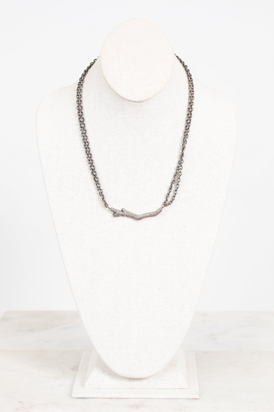 Necklace on a mannequin against a white background