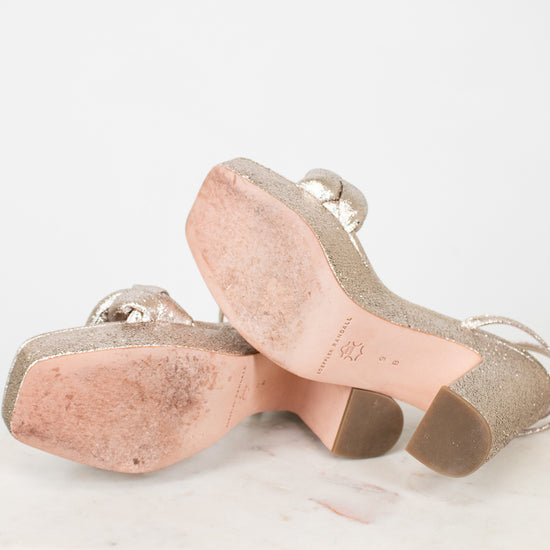 Pair of beige high-heeled shoes on a light gray background