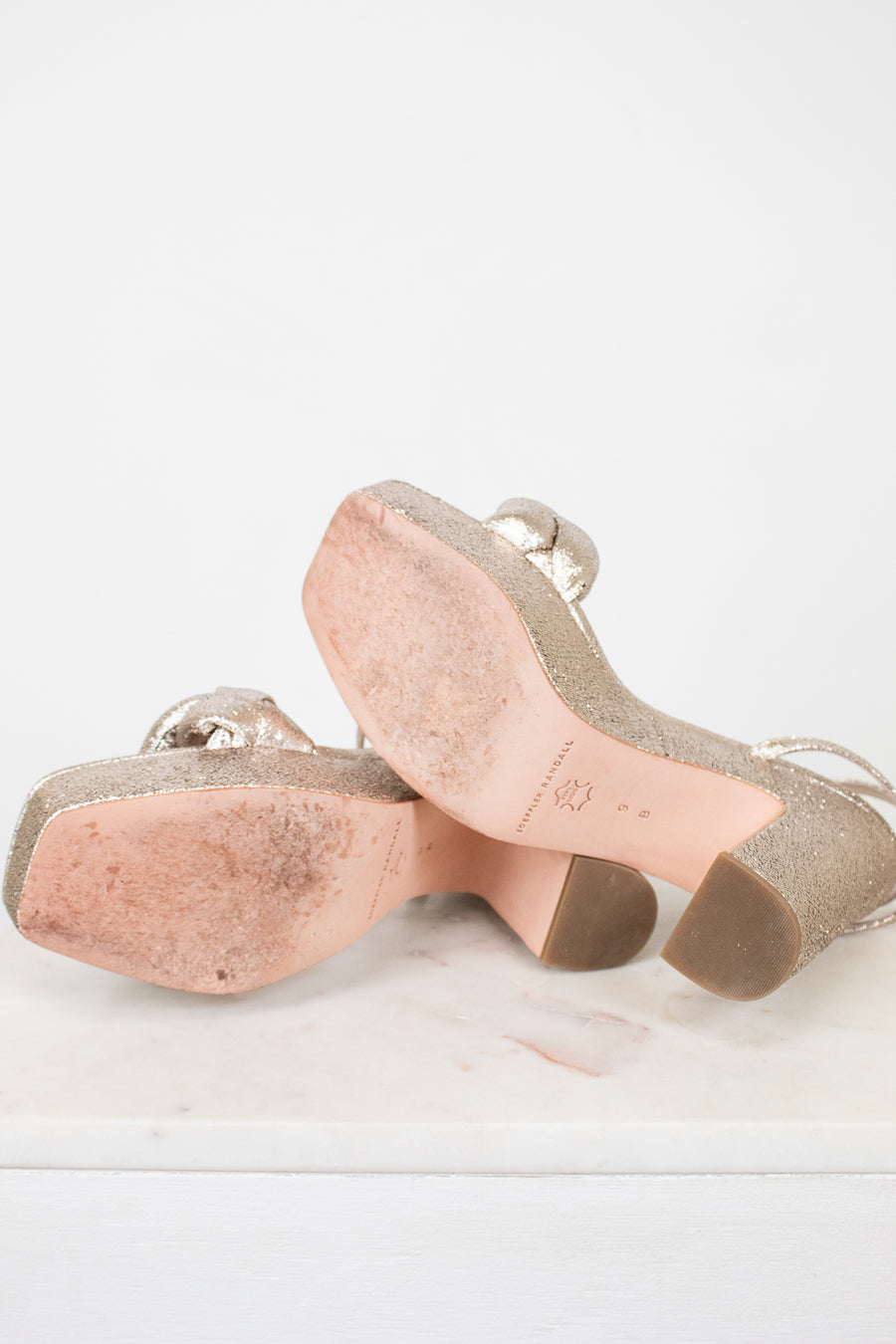 Pair of beige high-heeled shoes on a light gray background
