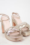 Gold glitter high-heeled sandals on a white background