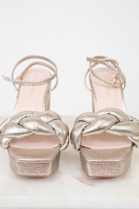 Pair of silver glitter high-heeled shoes on a white background