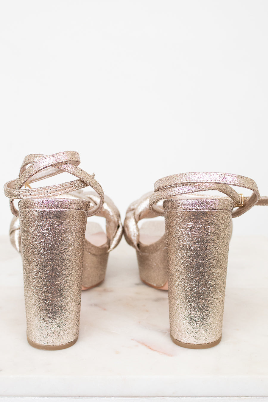 Pair of glittery high-heeled shoes on a white background