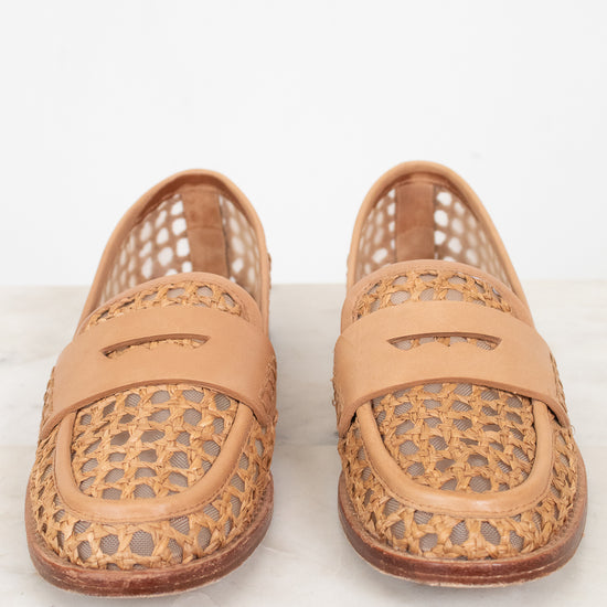 Pair of tan woven loafers on a light background