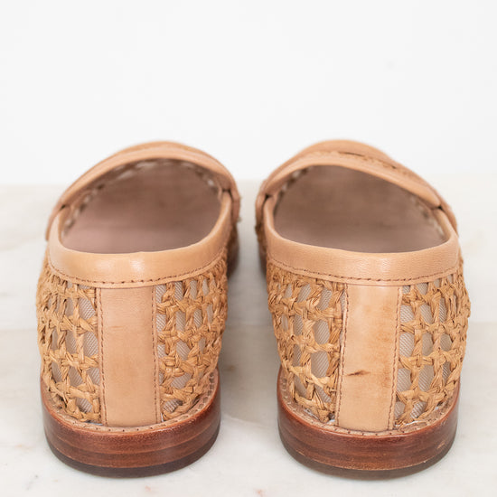 Pair of tan loafer shoes with wooden soles on a white background