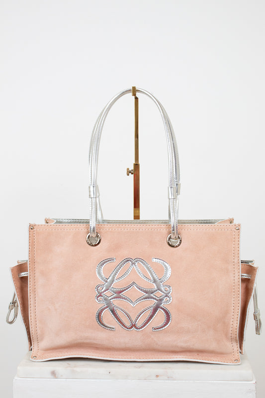 Pink handbag with a silver logo on a white background