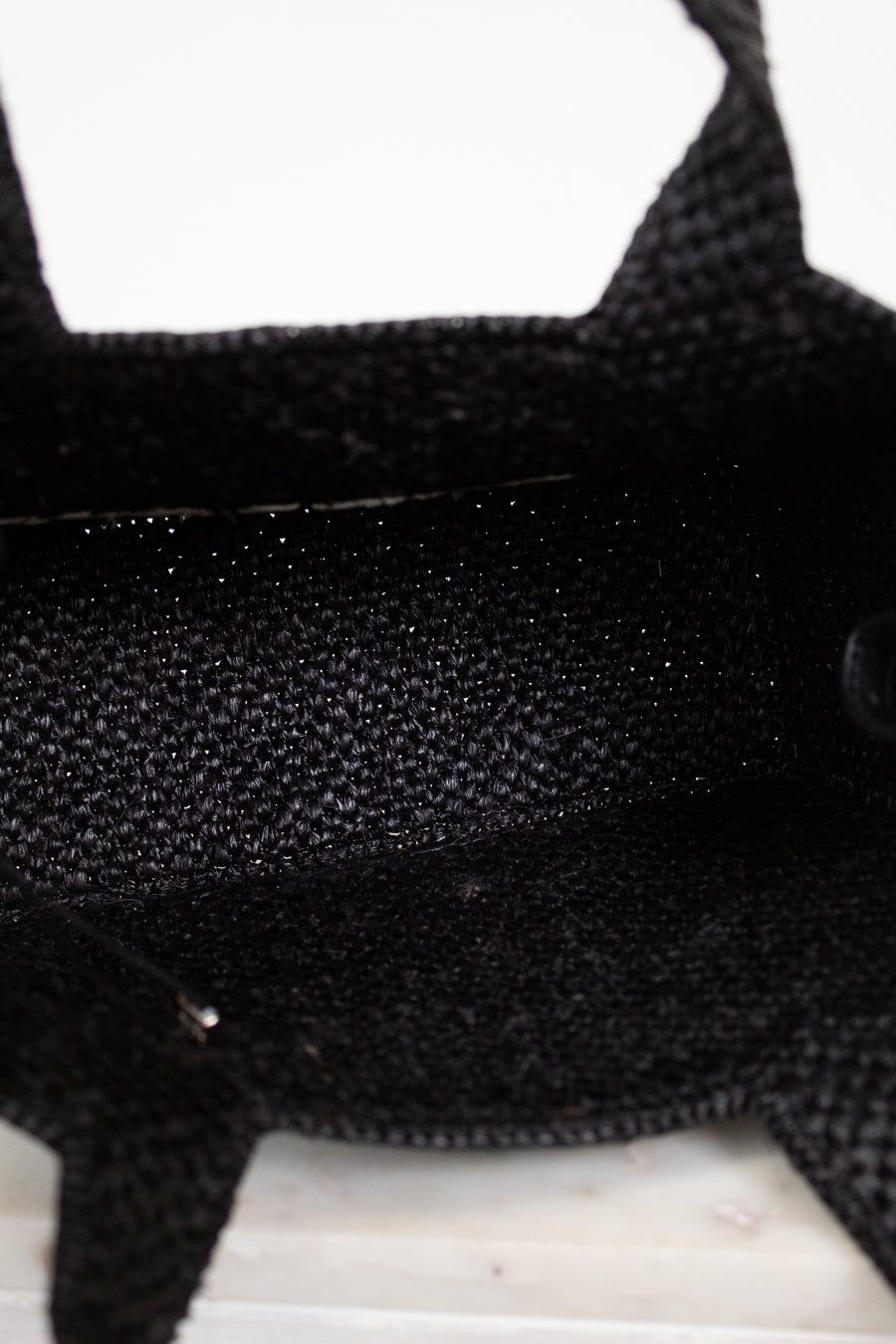 Close-up of black textured handbag interior on a white background