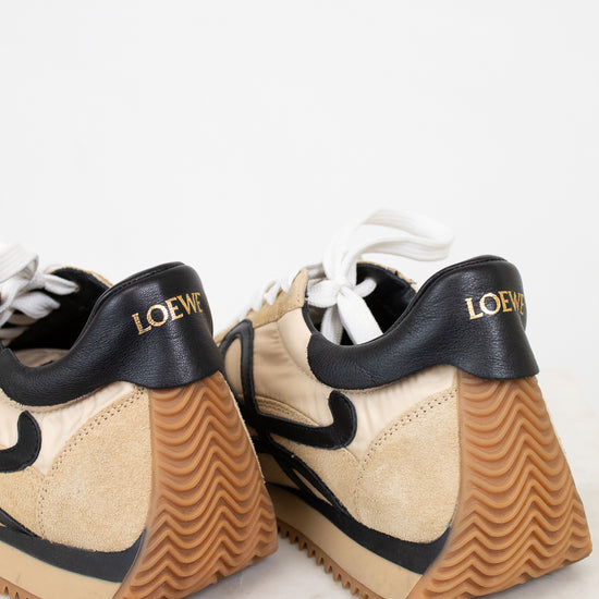 Pair of tan sneakers with black accents on a light background