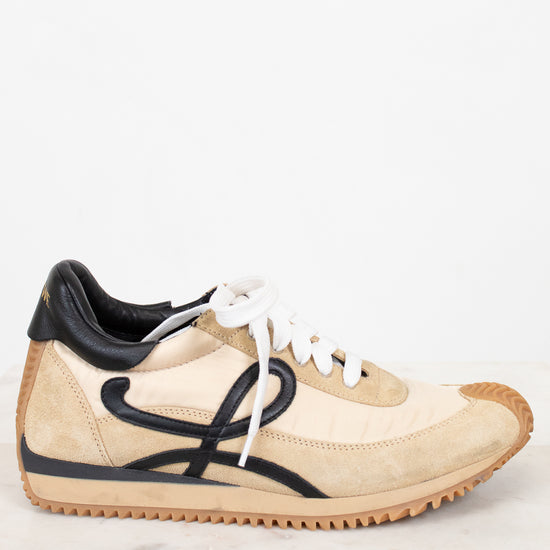 Beige sneaker with black accents on a white background