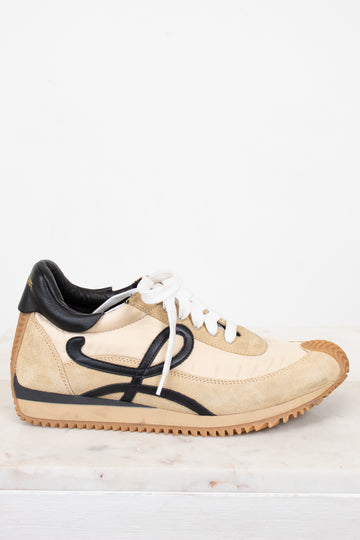 Beige sneaker with black accents on a white background