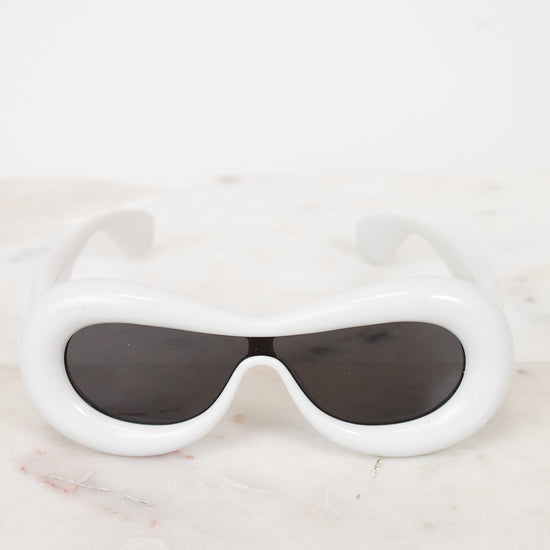 White sunglasses with black lenses on a marble surface