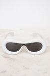 White sunglasses with black lenses on a marble surface