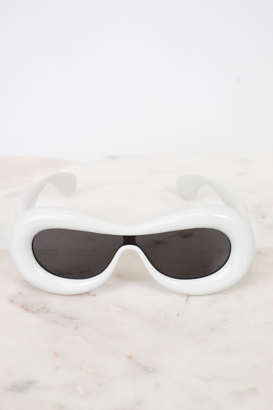 White sunglasses with black lenses on a marble surface