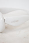 White sunglasses with 'LOEWE' branding on a marble surface