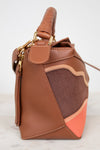 Brown leather handbag with gold accents on a white background