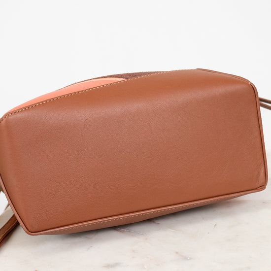 Brown leather handbag on a marble surface with a white background