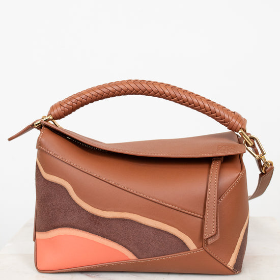 Brown handbag with a braided handle on a white background