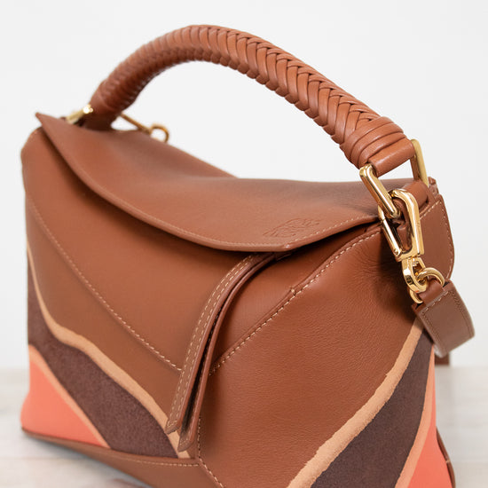 Brown handbag with gold details on a light background