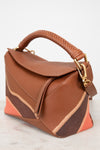 Brown handbag with gold details on a light background