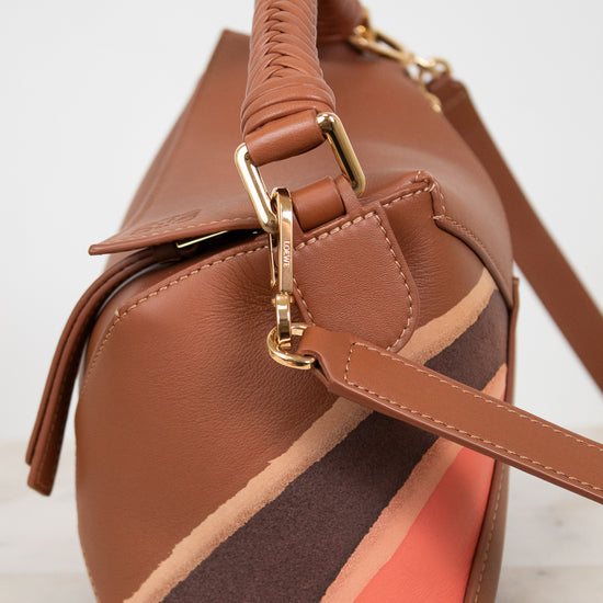 Brown handbag with a gold clasp on a light background