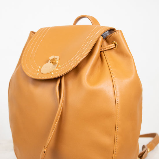 Tan leather backpack on a white background