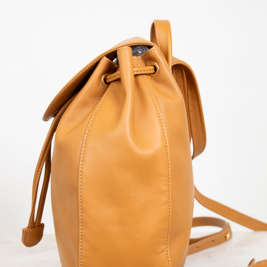 Tan leather bucket bag on a light background