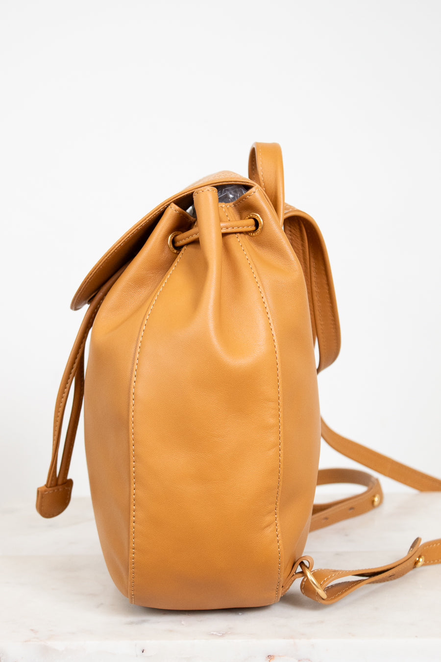 Tan leather bucket bag on a light background