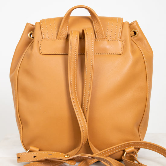Tan leather backpack with a strap on a white background