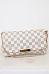 Checkered handbag with gold chain on a light gray background