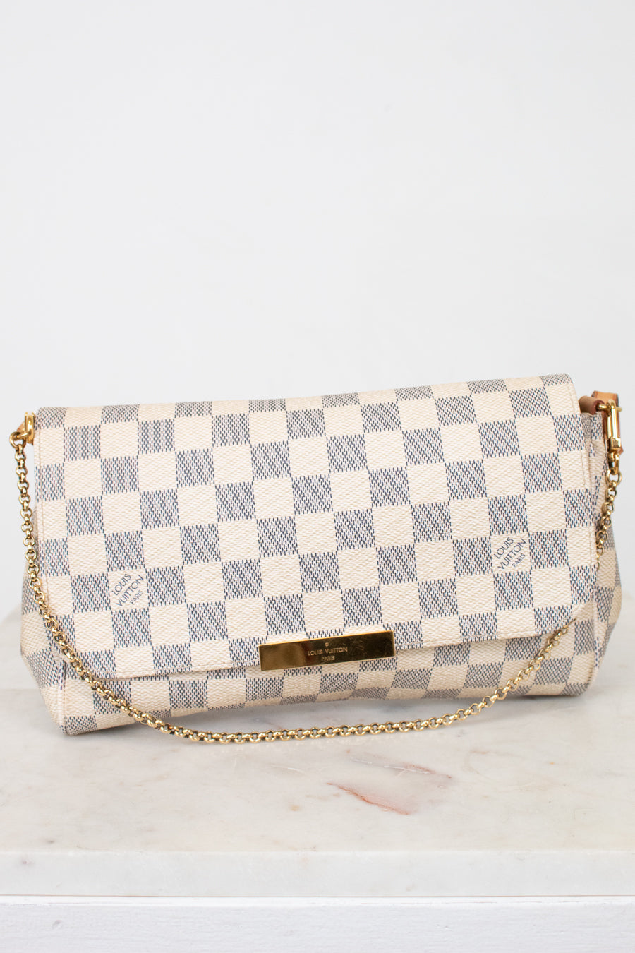 Checkered handbag with gold chain on a light gray background