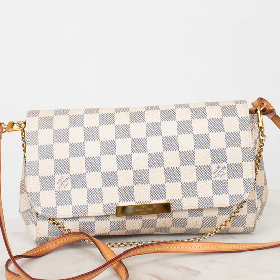 Checkered handbag with a brown strap on a white background