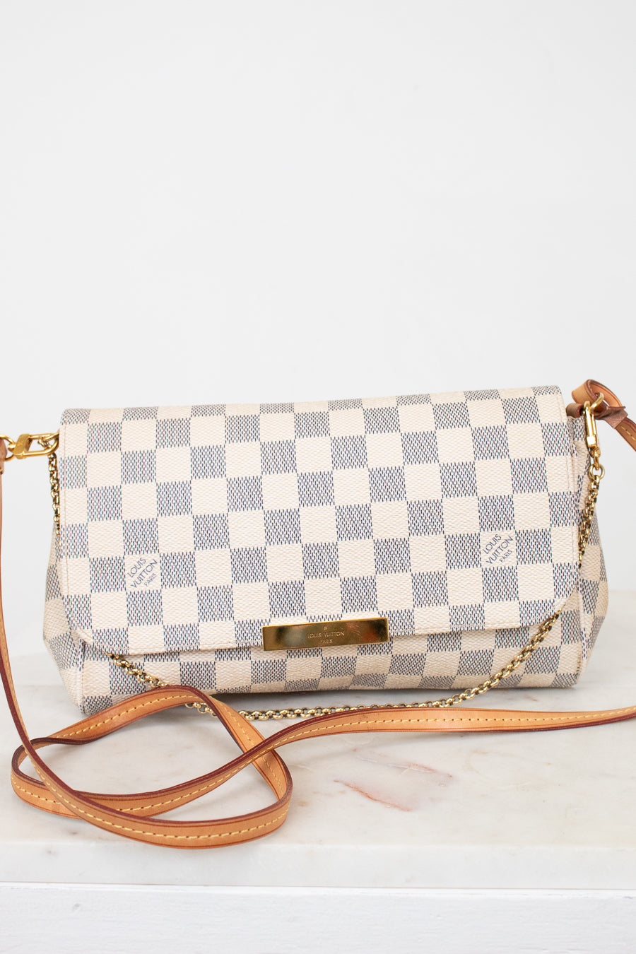 Checkered handbag with a brown strap on a white background