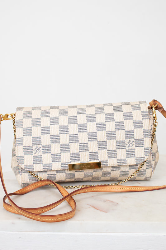 Checkered handbag with a brown strap on a white background