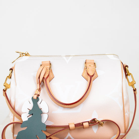 White handbag with brown strap and gold hardware on a white background