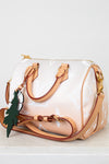 White and tan handbag with brown handles and trim on a white background