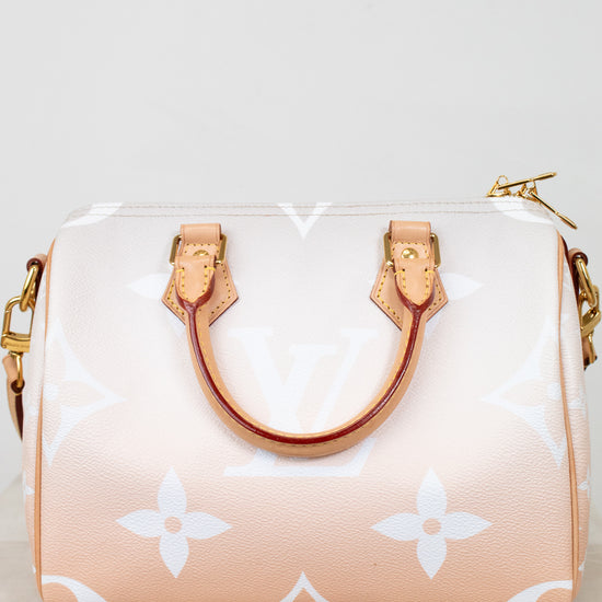 Designer handbag with a white logo pattern on a light background