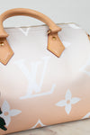 Designer handbag with beige handle and white monogram pattern on a light background