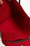 Red interior of a handbag with visible brand logo