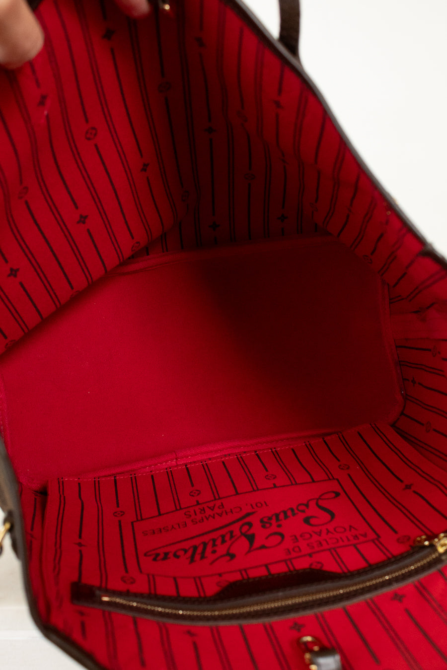 Red interior of a handbag with visible brand logo