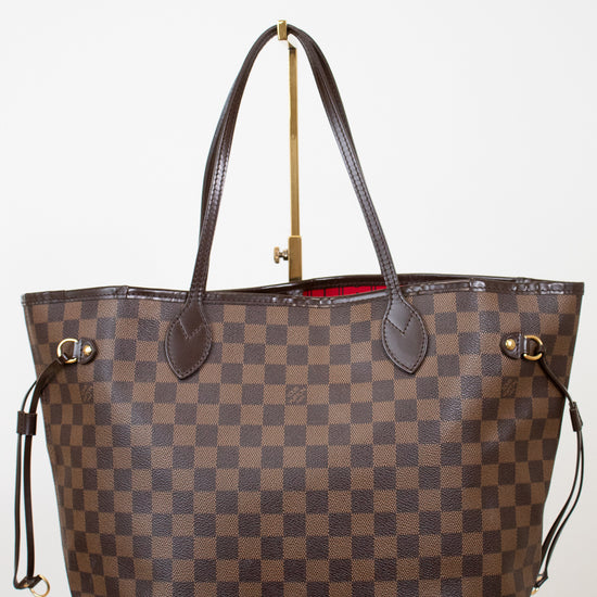 Brown checkered handbag with gold accents on a white background