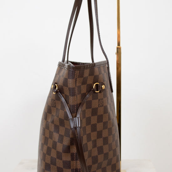 Brown checkered handbag with gold accents on a white background