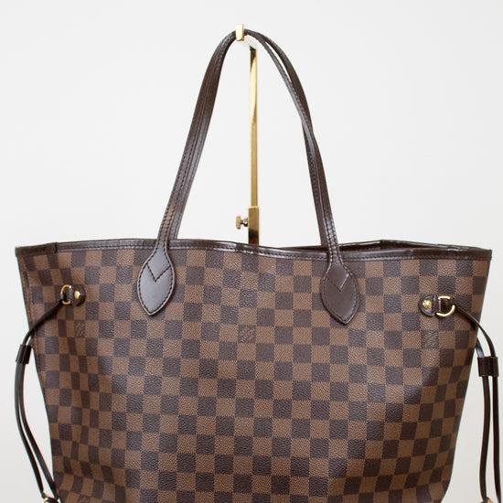 Brown checkered handbag with gold accents on a white background