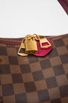 Designer handbag with gold locks and a pink tab on a white background